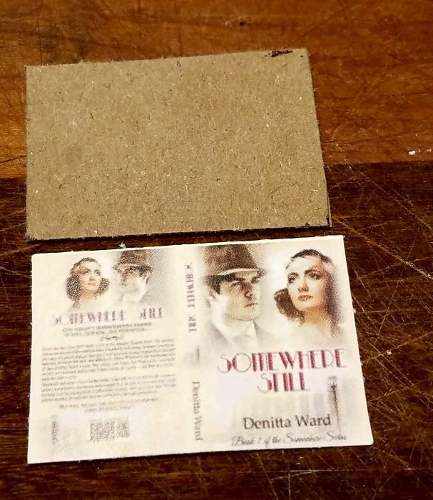 A sheet of thin cardboard next to a printed cover