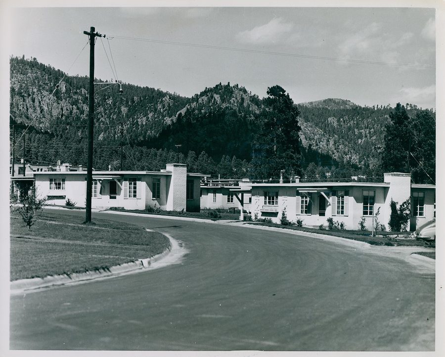 Historic photograph of wartime housing curving along a road in Los Alamos